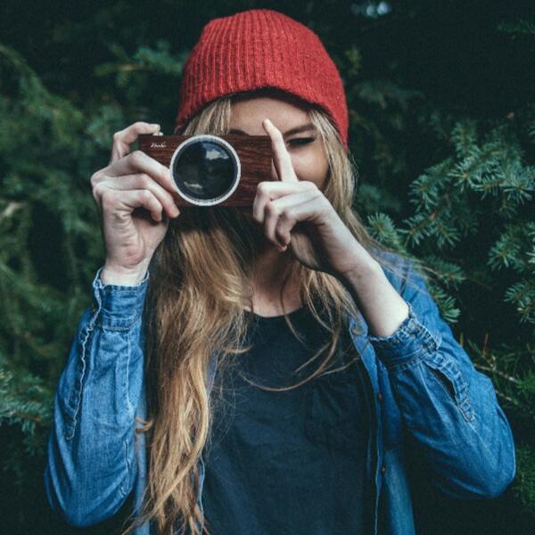 Photographer girl taking picture with wooden camera vintage look